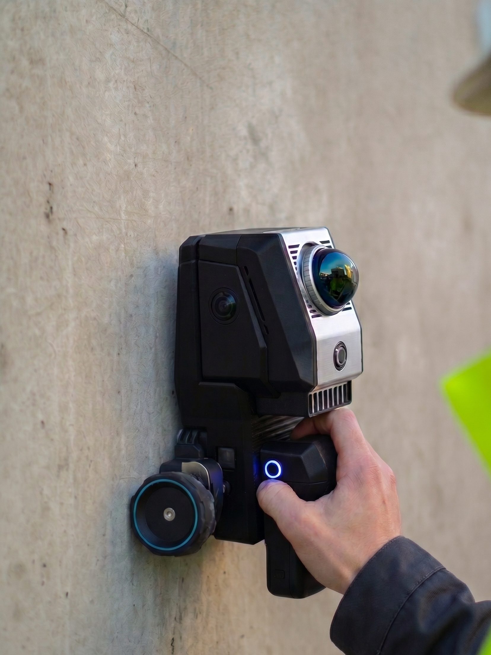 Operator in hi-vis holding the Birdsview scanner against rough concrete